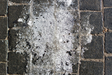 White ice on the sidewalk in the city