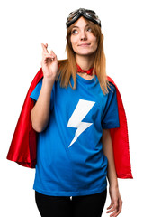 Pretty superhero girl with her fingers crossing