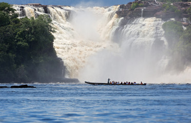 Waterfall and the boat with the tourists in the lagoon of Canaima national park - Venezuela - 139151603