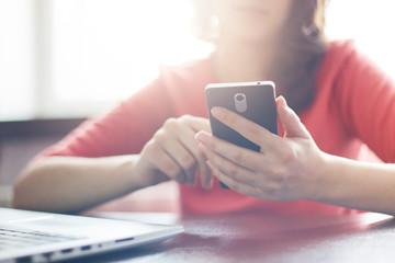 Film effect.  A shot of young female dressed in red casual sweater using high-speed Internet...