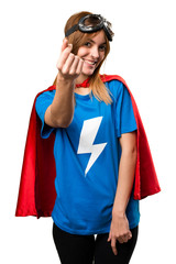 Pretty superhero girl making money gesture