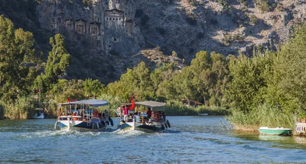 Fototapeten Tourist boats by the historic king tombs in Kaunos © broadcastertr