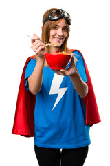 Pretty superhero girl eating cereals from a bowl © luismolinero