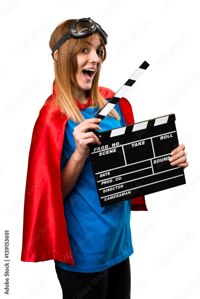 Wall mural Pretty superhero girl holding a clapperboard