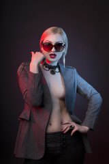 Seductive woman with decollete wearing glasses and dressed in jacket