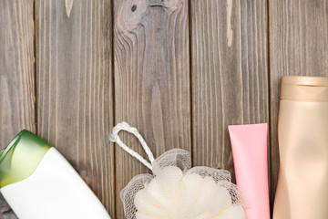 brush and cosmetics for shower on wooden background