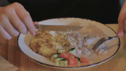 Close-up - handsome man eats a meat with fork and knife