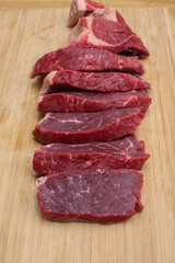 Fresh raw sliced meat beef on an wooden cutting board.