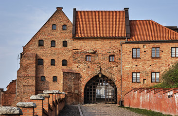 Paved street and the Gothic city gate in Grudziadz in Poland.