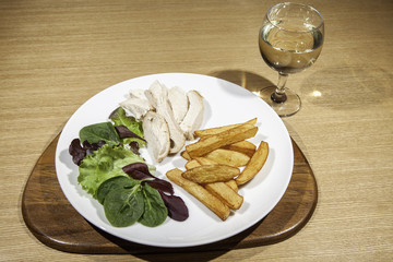 Slimmer's chicken meal with salad, fries and wine.