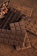 Dark homemade chocolate bars and cocoa pod on wooden