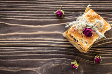 Stack of sweet crackers decorated with roses on rustic background