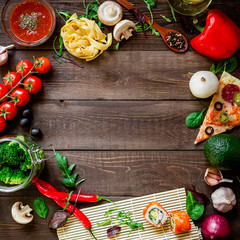 Vegetables and pizza, sushi rolls, pasta and sauce on wooden table. Flat lay. Food frame