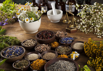 Natural medicine, herbs, mortar on wooden table background