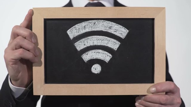 Wi-Fi zone sign drawn on blackboard in businessman hands, internet technology