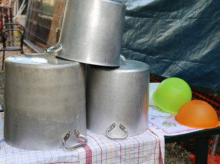 huge pots to dry and terrines in a camp kitchen