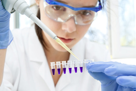 Young energetic female scientist or tech performing DNA test