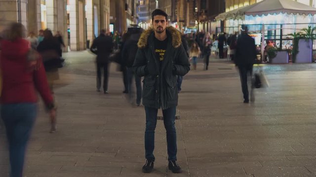 Timelapse of caucasian young man standing in the middle of crowd 4K ULTRAHD