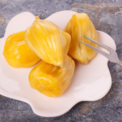 Tropical fruit Jackfruit (jakfruit, jack, jak) on plate with fork on cement background. Selective focus © jantima