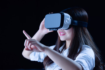 Asian Chinese young woman using vitual reality smart glasses in vitual space.low key photo