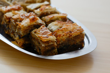 Traditional serbian cake baklava arranged on metal plate.