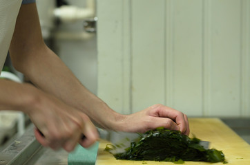 Chef cutting seaweed prepare food in restaurant,Hand cutting vegetable fast it's skill