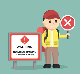 hiker standing beside danger sign