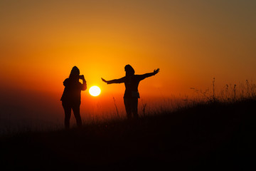 Silhouette Of People having fun at sunset time