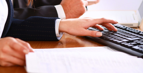 Young business woman and handsome businessman in headsets using laptops while working in office