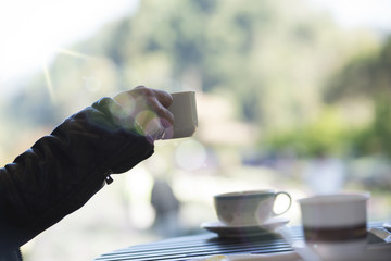 cup of coffee in hand, blank text and blur