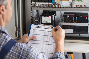 Male Technician Writing Reading Of Meter