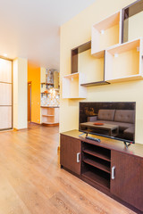 The interior of the living room in orange tones with TV