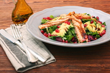 Salad with fried salmon, avocado and pomegranate seeds