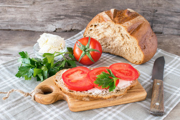 Sandwich of crispy bread  fresh tomatoes cream cheese with herbs