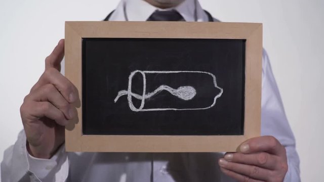 Sperm cell inside condom drawn on blackboard in doctor hands, birth control