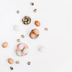 White and brown Easter eggs and quail eggs on white background. Flat lay, top view. Traditional spring concept.