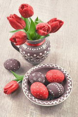 Easter eggs and tulips on wood