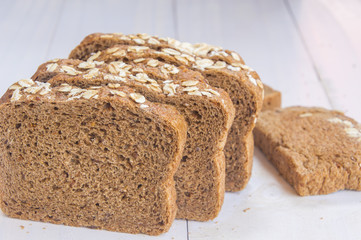 Fresh whole grain bread on white wood background