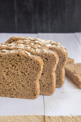 Fresh whole grain bread on white wood background