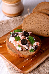 Smoked salmon and soft cheese spread, mousse, pate on a bread with olives and parsley