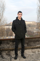 Photographing Danila Mazić with a black coat and black pants a background Petrovaradin fortress and the Danube, Novi Sad, Serbia