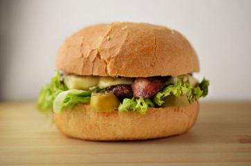 Tatsy burger with bacon and cheese on wooden table