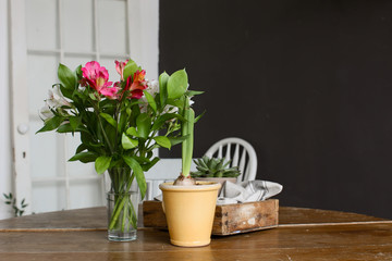 Vase and pot of flowers on table