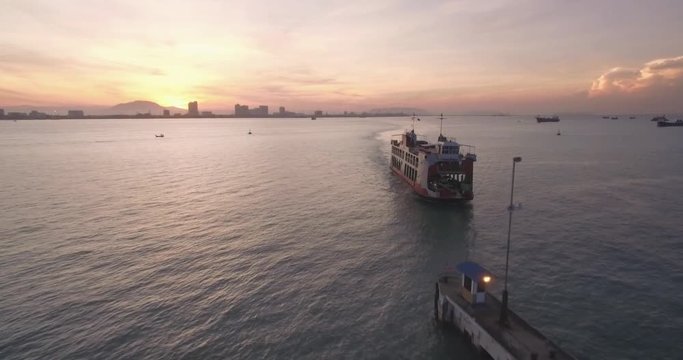 Sunrise Over Penang Car Ferry and Pier, Malaysia, Drone Pullback Shot
