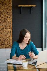 Naklejka premium Young woman working from the cafe