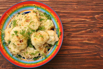 Fried cauliflower with cheese and greens