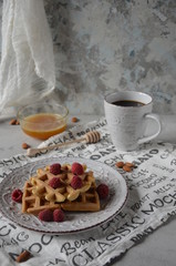 Belgian waffles with fresh raspberries, honey and cup of coffee