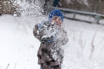 Fototapeta na wymiar Boy playing with snow in winter
