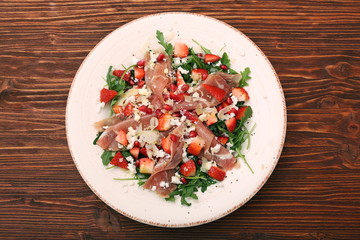 Arugula salad with strawberries, feta cheese, prosciutto, parmes