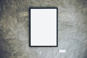 Mockup image of blank white picture frame on concrete polishing wall in loft style room